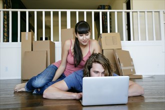Couple using laptop in new home