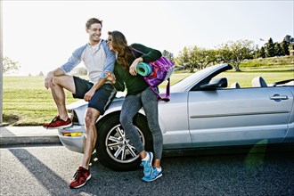 Couple wearing workout gear by convertible