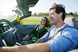 Couple driving in convertible