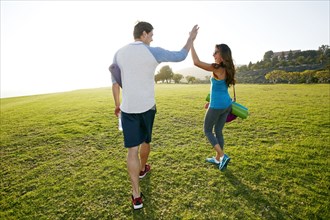 Couple high fiving in park