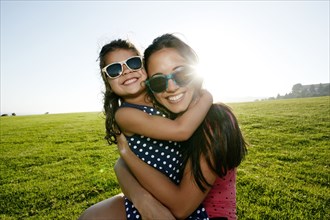 Mother and daughter smiling in field