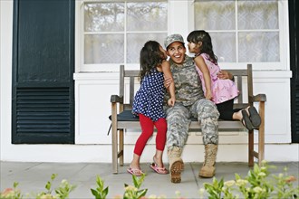 Soldier mother with daughters on patio
