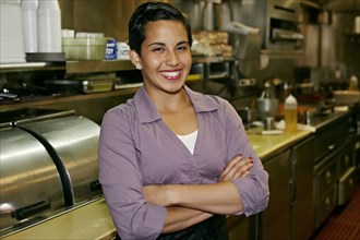 Hispanic waitress smiling in restaurant