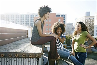 Women relaxing on urban rooftop