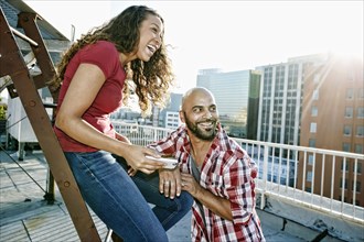 Couple relaxing on urban rooftop