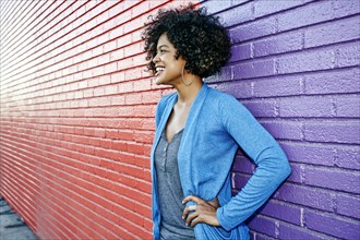 Mixed race woman standing by colorful wall