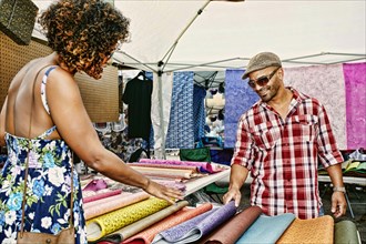 Couple browsing fabrics at flea market