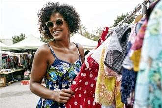 Mixed race woman shopping at flea market