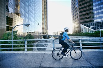 Caucasian businessman riding bicycle on urban street