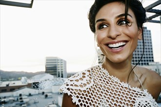Middle Eastern woman smiling on urban rooftop