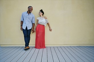 Couple standing against wall outdoors