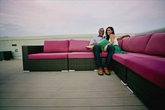 Couple relaxing on sofa outdoors
