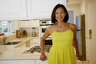 Mixed race woman smiling in kitchen