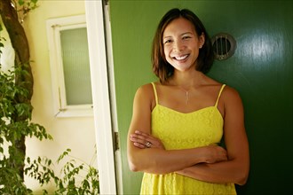 Mixed race woman smiling at front door