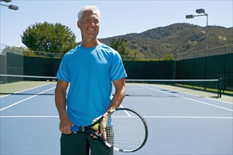 Caucasian man smiling on tennis court