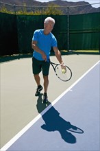 Caucasian man playing tennis on court
