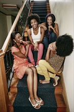 Women laughing on steps in apartment building
