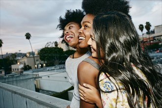 Women laughing together on urban rooftop