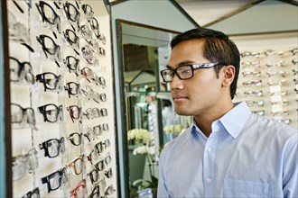 Filipino man trying on glasses at optometrist