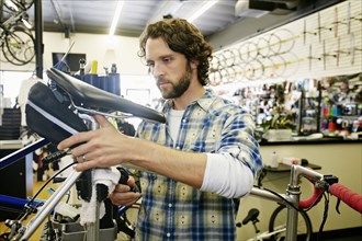 Caucasian man smiling in bicycle repair shop