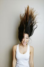 Mixed race woman tossing her hair