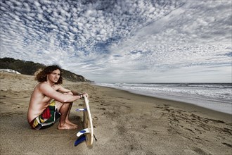 Caucasian man holding surfboard on beach