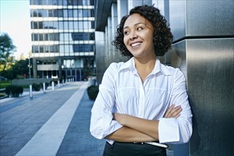 Mixed race businesswoman standing in city