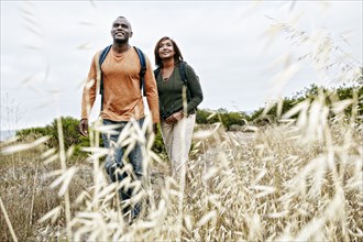 Black couple hiking on rural hillside