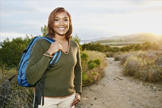 Black woman smiling on rural hillside