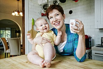 Caucasian mother and baby relaxing in kitchen