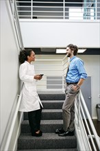 Doctor and businessman talking on staircase