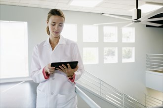 Caucasian doctor using digital tablet near railing