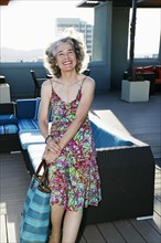 Caucasian woman holding purse on urban rooftop