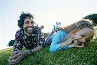 Father and daughter playing in grassy field