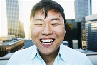 Korean man smiling on urban rooftop