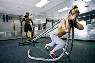 People working out with ropes in gym