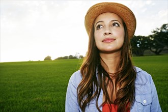 Hispanic woman smiling in grassy field