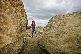 Hispanic woman hiking on rock formations