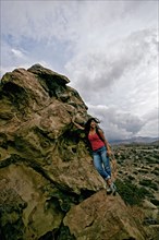 Hispanic woman standing on rock formation
