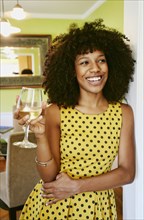 Mixed race woman drinking glass of white wine