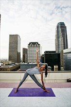 African American woman practicing yoga on urban rooftop