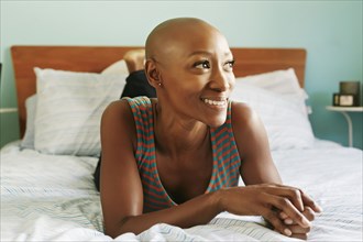 Smiling African American woman laying on bed