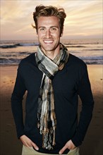 Smiling Caucasian man standing on beach