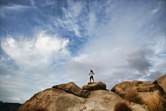 Vietnamese woman standing on rocky hilltop