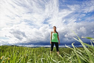 Mixed race athlete standing in rural field