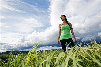 Mixed race athlete standing in rural field