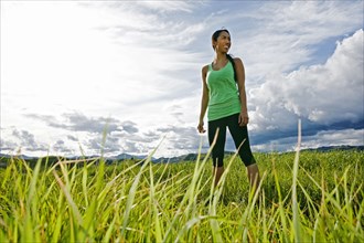 Mixed race athlete standing in rural field
