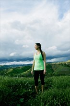 Mixed race athlete standing in on rural hilltop