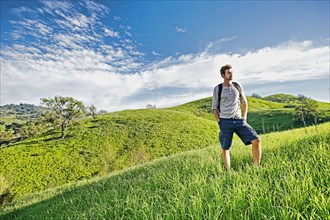 Caucasian man standing on rural hilltop
