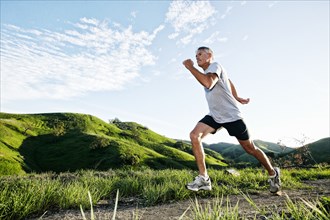 Older Caucasian man jogging on dirt path